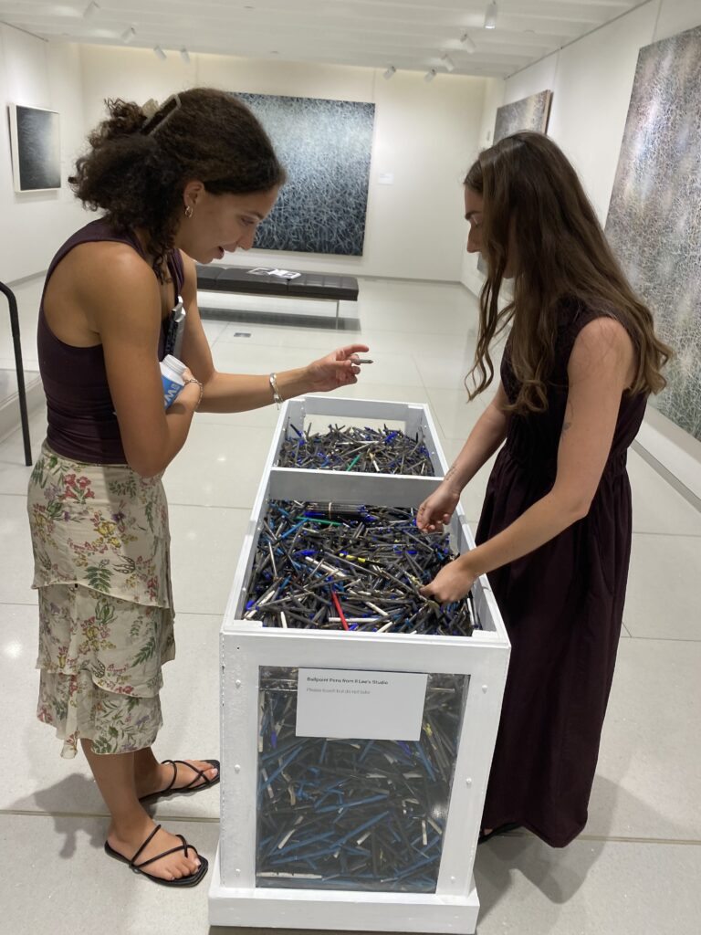 Writer Ella Bowers inspects piles of ballpoint pens used by artist Il Lee to create his works with the Vilcek Foundation's Olivia Wrobleski (Photo by Amos White V)