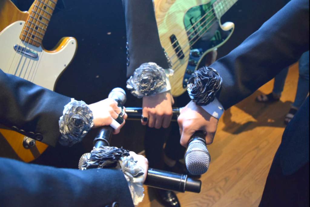 The Rose members pre-show ritual with silver roses fist bumping their microphones before their concert. Photo by Jaehyeong Lee